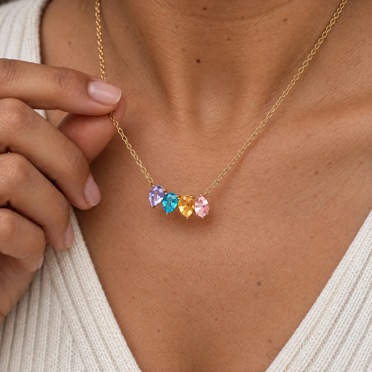 Mujer sosteniendo su Collar Raíces de cuatro piedras
